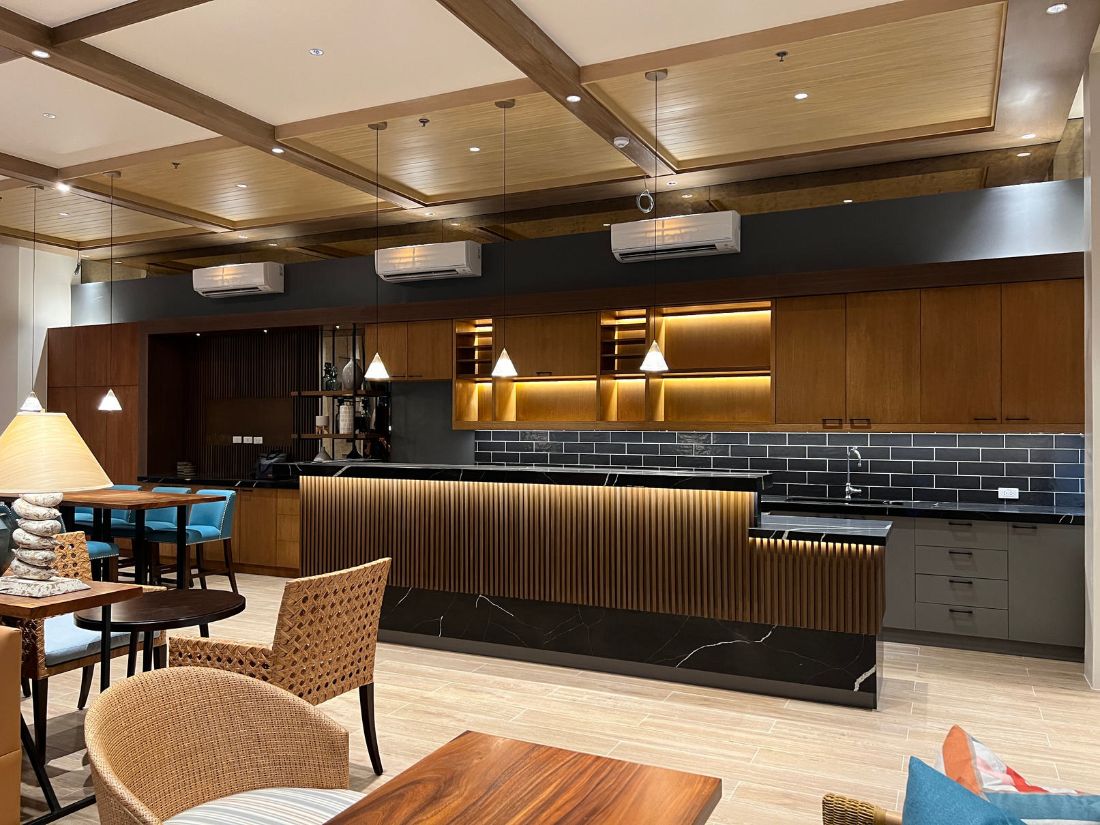 Fluted wood bar counter with a black stone top and lit back shelving